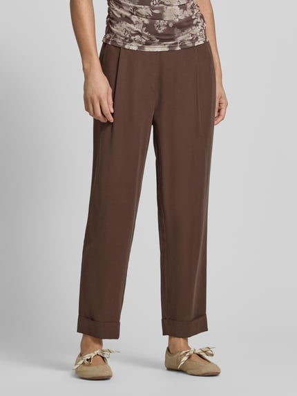 Kobiece model prezentuje spodnie materiałowe z francuskimi wpuszczanymi kieszeniami od Jake*s Collection, brąz, krój straight fit, elastyczny pas, stała zakładka na dole, z tyłu kieszenie z wypustką, szerokość w rozmiarze 38: 36 cm, długość wewnętrzna nogawki: 68 cm, widok na całe ciało z przodu.