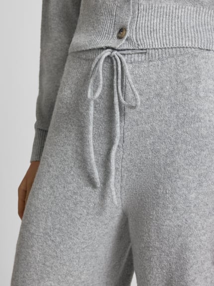 Frauenmodel trägt Wide Fit Strickhose mit geripptem Bund von REVIEW, grau, weiche Textur, mit Tunnelzug und Elastikbund, Nahaufnahme Oberkörper.