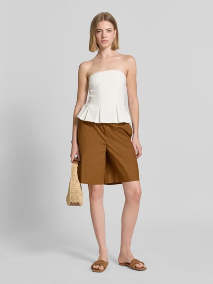 Frauenmodel trägt Straight Fit Shorts mit elastischem Bund von Rich & Royal aus Reine Baumwolle in Braun, Knielänge, glatte Textur, Ganzkörperansicht von vorne.
