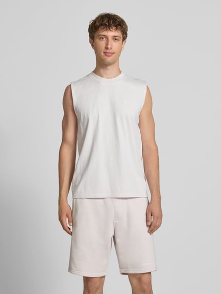 Männermodel trägt Tanktop mit Label-Stitching und Rundhalsausschnitt von Pegador aus Reine Baumwolle im Relaxed-Fit, Ganzkörperansicht von vorne. Rückenlänge bei Größe M: 66 cm.