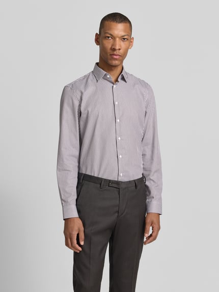 Mannelijk model draagt Slim Fit Business-Hemd met kentkraag van Jake*s in puur katoen, smalle streep, knoopsluiting, sportmanchet, afgeronde zoom, verlengde rug, ruglengte maat 39/40: 78 cm, schouderbreedte: 47 cm, mouwlengte: 66 cm, voorkant volledige lichaamsaanzicht.