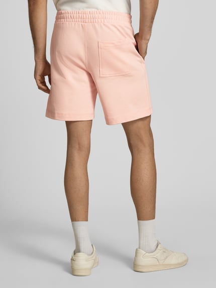Männermodel trägt Sweatshorts mit Stitching Modell 'KARL' von Jack & Jones in Hellrosa, Baumwoll-Mix, elastischer Bund, Ganzkörperansicht Rückansicht