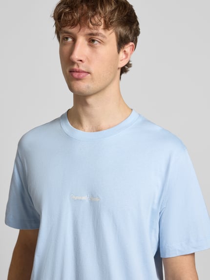 Männermodel trägt hellblaues T-Shirt mit Label-Stitching Modell 'NORREBRO' von Jack & Jones, reine Baumwolle, Nahaufnahme Oberkörper.