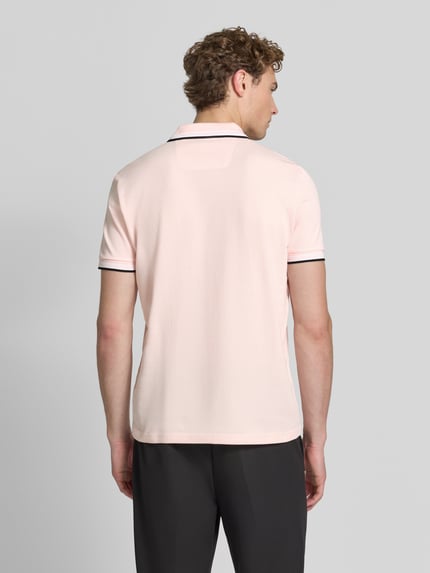 Mężczyzna model nosi jasnoróżową koszulkę polo Regular Fit Poloshirt aus reiner Baumwolle model 'PADDY' od BOSS Green, gładka tekstura, całkowity widok z tyłu.