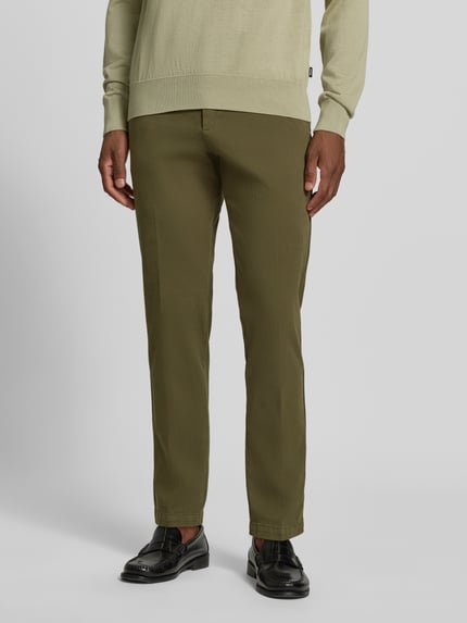 Männermodel trägt Slim Fit Chino aus Baumwoll-Mix Modell 'Kaiton1' von BOSS, olivegrün, glatte Textur, Nahaufnahme Unterkörper, Herren Schmale Hose von BOSS.