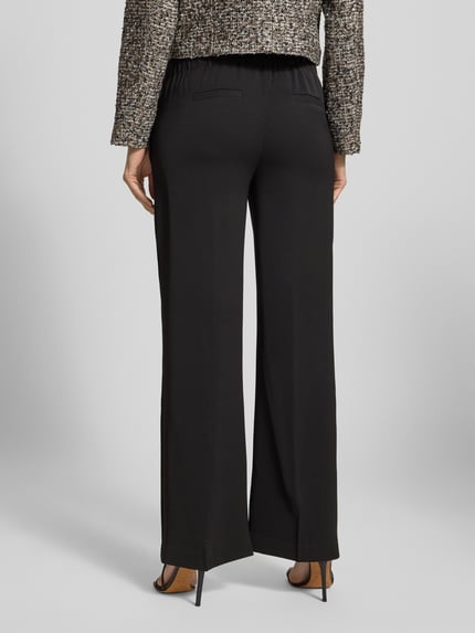 Vrouwenmodel draagt Stoffhose aus Viskose-Mix Modell 'Damai' van B.Young, zwart, wijde pijpen, elastische taille, Ganzkörperansicht Rückansicht.