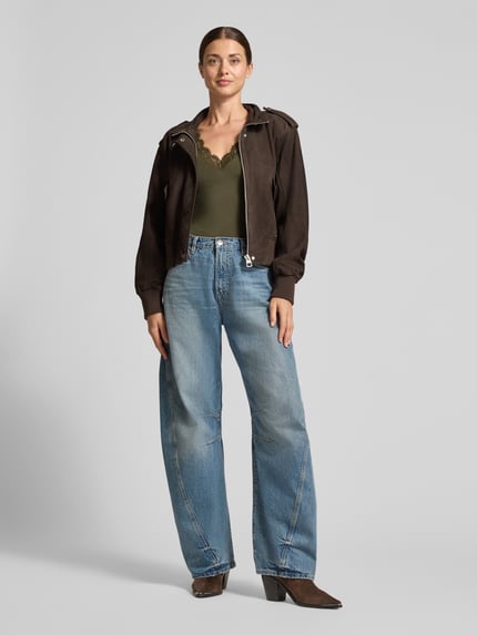 Frauenmodel trägt Slim Fit Langarmshirt aus Modal-Mix mit Woll-Anteil Modell 'SKYE' von VERO MODA in Olivgrün, Ganzkörperansicht von vorne.