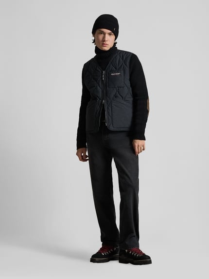 Männermodel trägt die Regular Fit Steppweste mit Brusttasche von Polo Ralph Lauren in Unifarben mit V-Ausschnitt, Ganzkörperansicht von vorne.