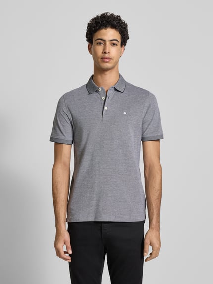 Męski model nosi Slim Fit Poloshirt mit Viskose-Anteil Modell 'Paulos' von Jack & Jones, szary kolor, krótki rękaw, całkowity widok z przodu.