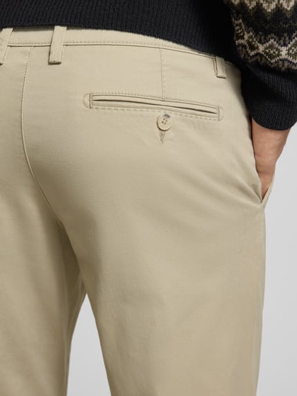 Mannenmodel draagt Stoffhose met Gesäßtaschen van Christian Berg Men in beige, katoenmix met bio-katoen, detailopname achterkant.