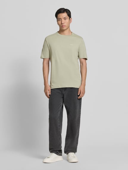 Męski model nosi Regular Fit T-Shirt aus reiner Baumwolle Modell 'DERO222' von HUGO, efekt: jednolity kolor, krój regular fit, aplikacja: nadruk z logo, okrągły dekolt, krótki rękaw, wykończenie materiału: dżersej, materiał: czysta bawełna, Ganzkörperansicht von vorne.