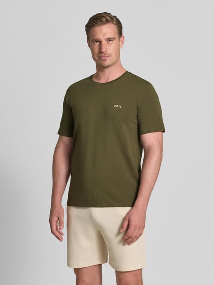 Männermodel trägt Regular Fit T-Shirt aus Baumwoll-Mix von BOSS in Olivgrün mit glatter Textur, Ganzkörperansicht von vorne. Herren T-Shirt von BOSS