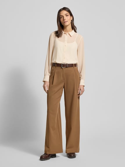 Modelka kobieca nosi Regular Fit Bluse in semitransparenter Optik od JOOP!, beżowa bluzka, półprzezroczysta, koszulowy kołnierzyk, długi rękaw, widok całej sylwetki z przodu.