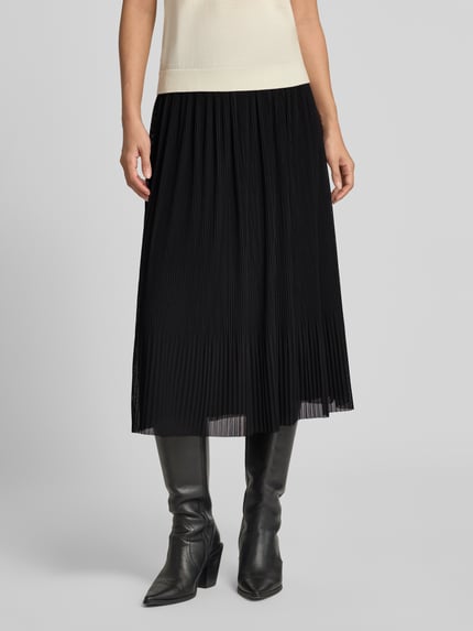 Frauenmodel trägt Plisseerock mit elastischem Bund von COMMA in Schwarz, Midilänge, feine Plisseefalten, Ganzkörperansicht von vorne.