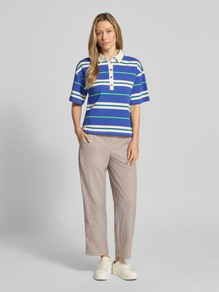 Vrouwenmodel draagt Regular fit stoffen broek met steekzakken model 'OPHELIA' van Cambio in beige, elastische band, verkorte benen, vooraanzicht, context: dames stoffen broek van Cambio, regular fit, elastische band, steekzakken, verkort, bandwijdte maat 36: 42 cm, binnenbeenlengte maat 36: 69 cm. Ganzkörperansicht von vorne
