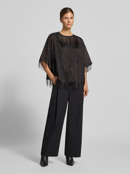 Frauenmodel trägt Cropped Kurzarmbluse mit Fransenbesatz von BOSS in Schwarz, Chiffon mit Struktur und semitransparenten Fransen, Ganzkörperansicht von vorne.