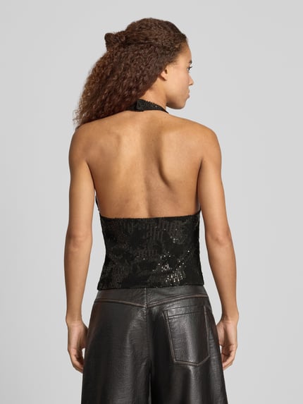 Frauenmodel trägt schwarzes Top mit Pailletten Modell 'SIGNA' von NOISY MAY®, Slim Fit, Neckholder, Rückenansicht, Material-Mix mit Stretch-Anteil, 50 cm Rückenlänge in Größe S.