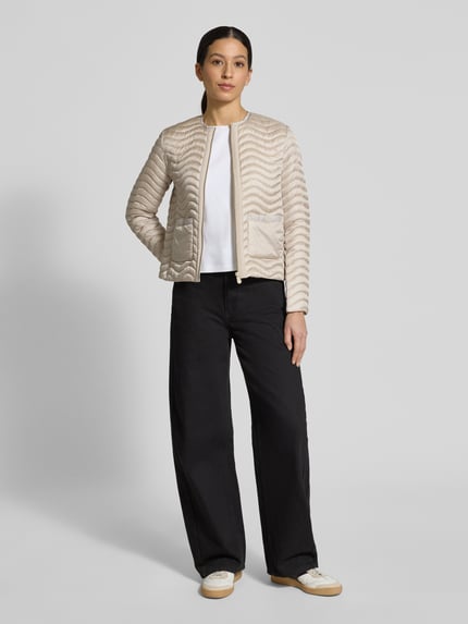 Modelka damska ma na sobie Slim Fit Steppjacke mit aufgesetzten Taschen Modell 'Tamina' von SAVE THE DUCK w beżowym kolorze, steppowana faktura, z okrągłym dekoltem, zapinana na zamek, kieszenie naszywane, krój slim fit, długość tyłu w rozmiarze S: 55 cm, szerokość ramion w rozmiarze S: 38 cm, szerokość klatki piersiowej w rozmiarze S: 47 cm, długość rękawa w rozmiarze S: 62 cm, widok całej sylwetki z przodu