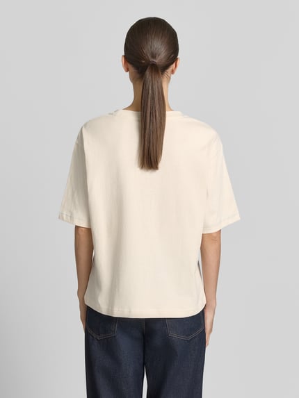 Kobiece model prezentuje damski t-shirt z nadrukiem z motywem i okrągłym dekoltem od Jake*s Casual, 100% bawełna, krój relaxed fit, długość tyłu w rozmiarze S: 58 cm, widok całej sylwetki od tyłu.