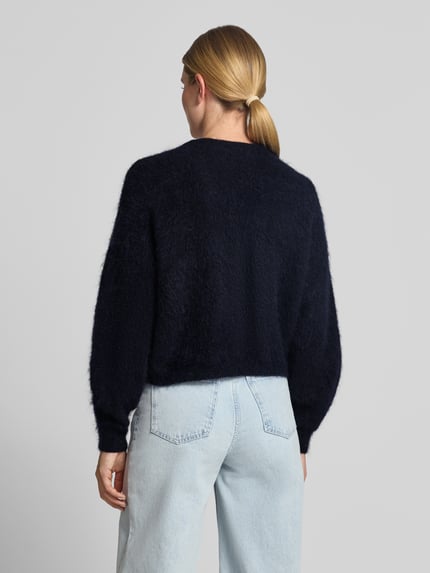 Frauenmodel trägt Oversized Wolljacke mit Woll- und Mohair-Anteil Modell 'Debbie' von Gestuz, dunkles Blau, Fell-Optik, Ganzkörperansicht Rückansicht. Damen Wolljacke, elastischer Material-Mix, V-Ausschnitt, Knopfleiste, elastische Ärmelenden, Rückenlänge ca. 52 cm, Ärmellänge ca. 69 cm.