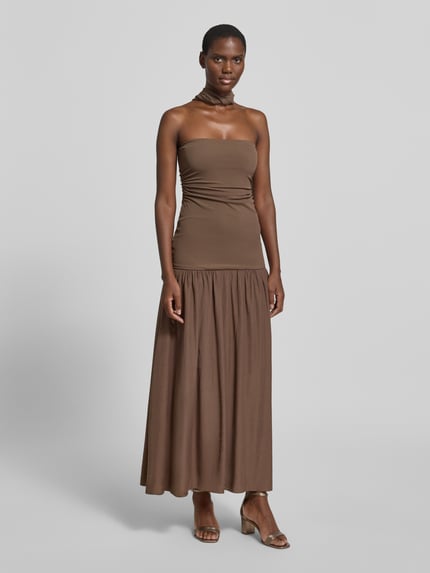 Modelka nosi długa sukienka z głębokim dekoltem na plecach Maxikleid mit tiefem Rückenausschnitt von Little Mistress, mieszanka materiałów z dodatkiem streczu, podkreślająca figurę, drapowania, długość tyłu w rozmiarze 36: 121 cm, szerokość w rozmiarze 36: 30 cm, brązowy kolor, proste linie, gładka faktura, Ganzkörperansicht von vorne.