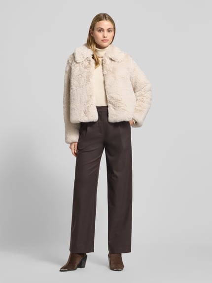 Vrouwenmodel draagt Jacke aus Kunstfell mit Eingrifftaschen van Milano Italy, beige kunstbont, regular fit, voorkant geheel zichtbaar, Ganzkörperansicht von vorne.