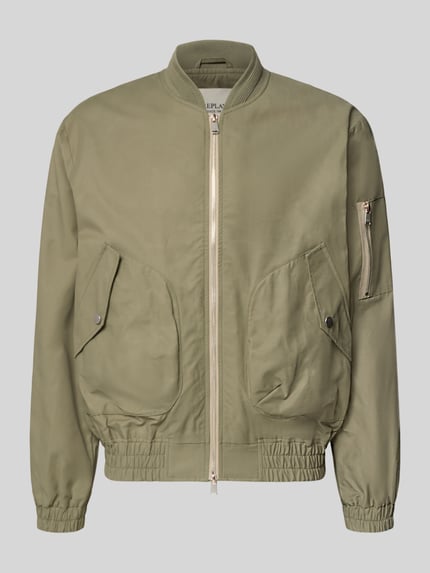 Produktfoto, Bomberjacke mit Reißverschlusstasche am Ärmel von Replay in Olivgrün, Baumwoll-Mix, gerader Schnitt, elastische Abschlüsse, Stehkragen, Zweiwege-Reißverschluss, sichtbare Textur der Baumwolle, Pattentaschen mit Druckknopfverschluss, Vorderansicht.