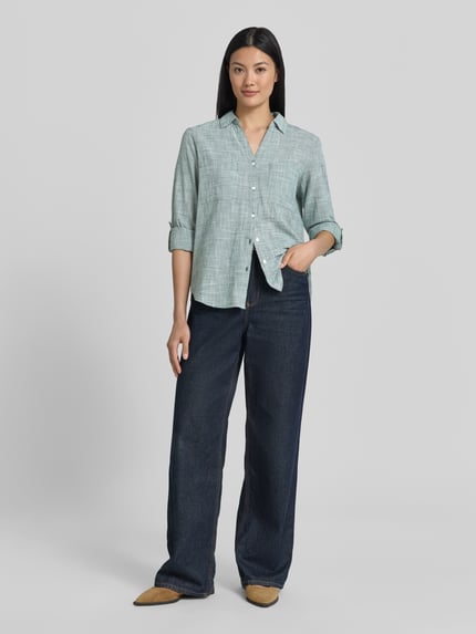 Frauenmodel trägt Regular Fit Hemdbluse aus reiner Baumwolle von Tom Tailor mit Hahnentritt Allover-Muster in mintgrün, Ganzkörperansicht von vorne.