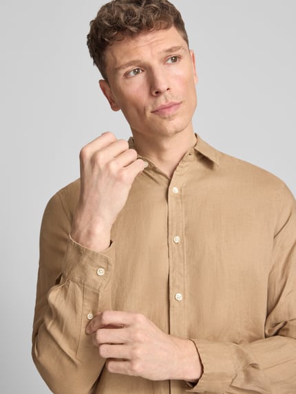 Männermodel trägt Regular Fit Leinenhemd aus reinem Leinen Modell 'CORE' von Scotch & Soda in Beige, Kentkragen, Langärmelig, Nahaufnahme Oberkörper. Rückenlänge bei Größe M: 78 cm, Schulterbreite: 45 cm, Ärmellänge: 66 cm, Durchgehende Knopfleiste, Label-Stitching, feine Struktur.
