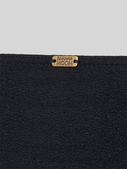 Produktfoto, Bikini-Slip mit Label-Detail Modell 'ALERIA' von Banana Moon, czarny materiał o drobnoziarnistej fakturze, damski kontekst