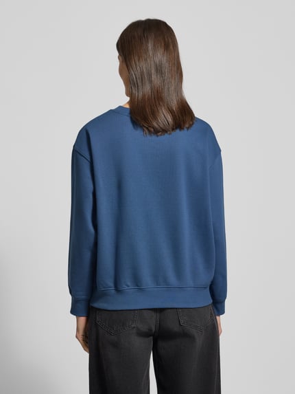 Frauenmodel trägt Regular Fit Sweatshirt aus Baumwoll-Mix von Tom Tailor Denim in Unifarbe Blau, gerippte Abschlüsse, Ganzkörperansicht Rückansicht.