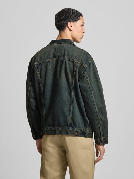 Männermodel trägt Relaxed Fit Jeansjacke aus reiner Baumwolle Modell 'TRUCKER' van Levi's®, denimlook met effen kleur, achteraanzicht