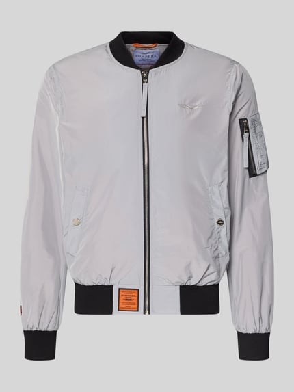 Produktfoto, Bomberjacke mit Label-Patch und Eingrifftaschen von Original Bombers in Hellgrau mit Reißverschluss, Reißverschlusstasche am Ärmel, Gerippte-Abschlüsse, Gerader-Schnitt, Größe M: Rückenlänge 67 cm, Schulterbreite 43 cm, Brustweite 53 cm, Ärmellänge 68 cm, glatte Textur, Details in Schwarz und Orange.