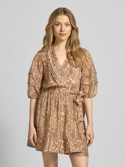 Frauenmodel trägt Minikleid mit V-Ausschnitt Modell 'TEODORA' von Bash aus Lyocell-Mix, taillierter Schnitt, 1/2-Arm, florale Muster, beige-braune Farbtöne, leichte Textur, Rückenlänge bei Größe S: 88 cm, Brustweite: 47 cm, Ärmellänge: 42 cm, Ganzkörperansicht von vorne.