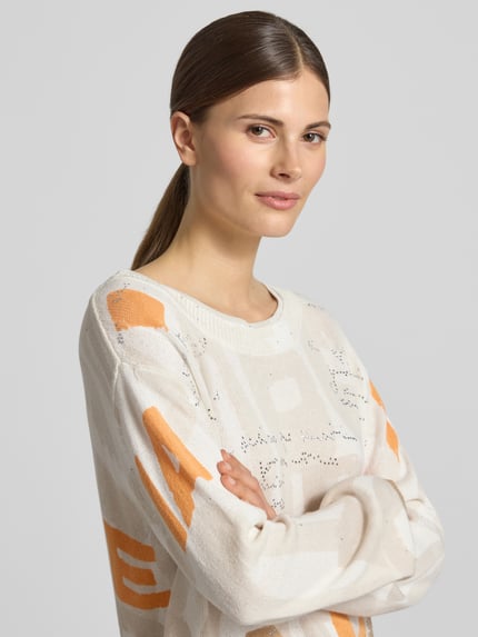 Vrouwenmodel draagt Pullover met Strasssteinbesatz van monari in beige-oranje, katoenmix, rechte fit, ronde hals, schouderdetails, close-up bovenlichaam.