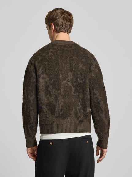 Männermodel trägt Cardigan mit Knopfleiste von ONLY in brauner Strickoptik mit marmoriertem Muster und Rippbündchen, Ganzkörperansicht Rückansicht.