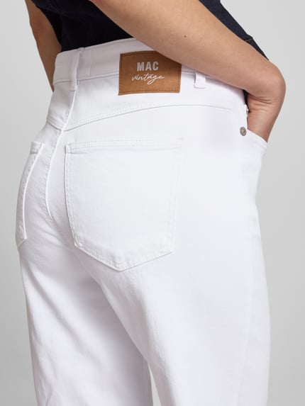 Frauenmodel trägt Flared Fit Jeans im 5-Pocket-Design von MAC aus weißem Baumwoll-Mix mit Knopf-Reißverschluss, Detailaufnahme Rückansicht.