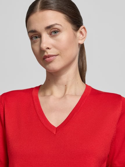 Modelka kobieca nosi Strickshirt mit V-Ausschnitt Modell 'Katie' od FREE/QUENT, czerwony, z mieszanki wiskozy z elastanem, krój regular fit, zbliżenie na górną część ciała.