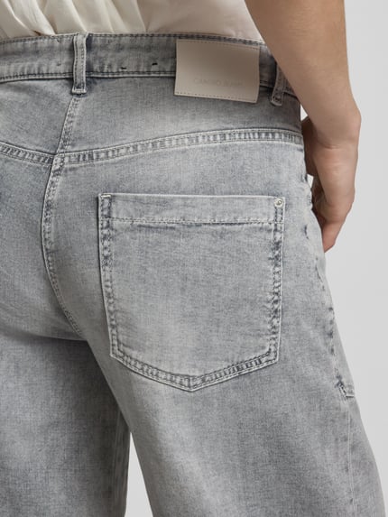 Frauenmodel trägt Barrel Fit Jeans aus Baumwoll-Mix Modell 'OCEAN' von Cambio in grauer Denim-Optik mit Label-Patch, Detailaufnahme.
