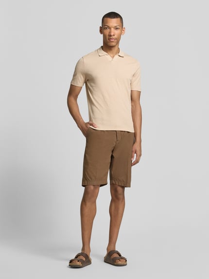 Männermodel trägt Modern Fit Poloshirt mit Polokragen und Label-Detail von MARKUP aus Reiner Baumwolle in Beige, Ganzkörperansicht von vorne.