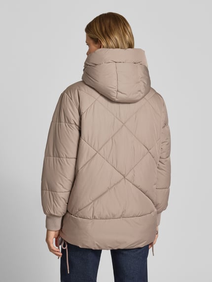 Frauenmodel trägt Relaxed Fit Steppmantel mit Kapuze von Marc O'Polo in Beige mit Rautensteppung, Damen Steppmantel, Ganzkörperansicht Rückansicht.