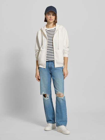 Modelka nosi Jeans mit 5-Pocket-Design od Levi's®, jasnoniebieski denim, luźny krój, przetarcia, używany wygląd, zdjęcie całej sylwetki z przodu.