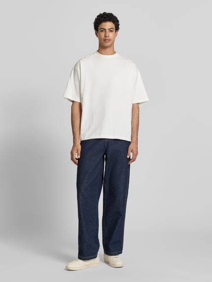 Männermodel trägt Oversized T-Shirt mit Rundhalsausschnitt von PROHIBITED aus Reine Baumwolle; weiße Farbe, glatte Textur, Ganzkörperansicht von vorne.