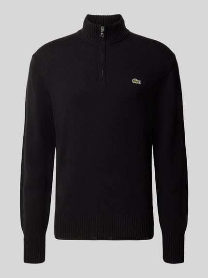 Produktfoto, Troyer aus Wolle mit Logo-Patch von LACOSTE in Schwarz, unifarben, Strickoptik, Reißverschluss, gerippte Abschlüsse, Feinstrick-Struktur.