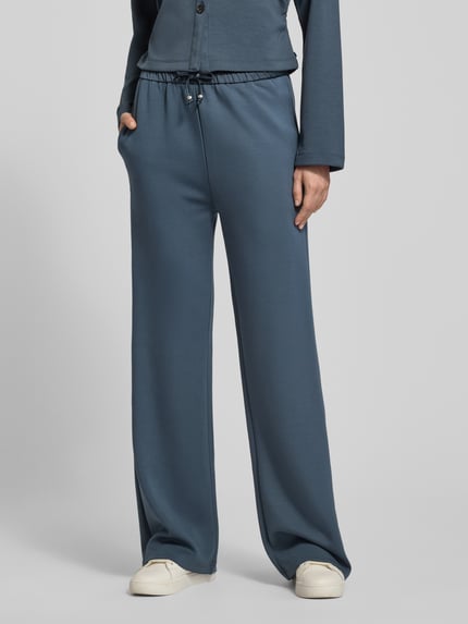Frauenmodel trägt Sweatpants mit elastischem Bund und Eingrifftaschen von Scotch & Soda, Blau, weites Bein, Modal-Mix, Ganzkörperansicht von vorne. Damen Sweatpants, Material-Mix, Eingrifftaschen, Innenbeinlänge bei Größe S 80 cm.