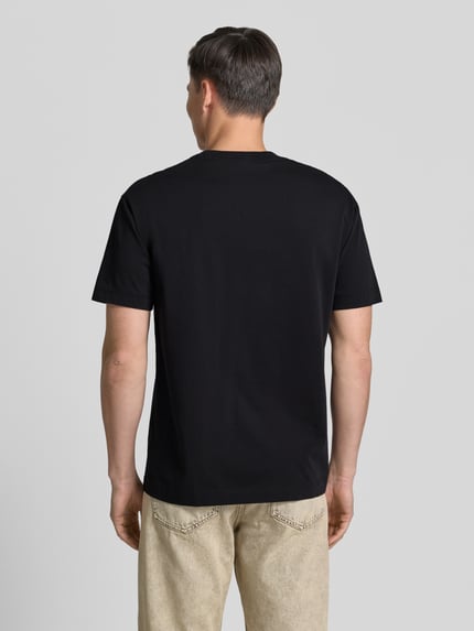 Männermodel trägt Relaxed Fit T-Shirt aus reiner Baumwolle von Marc O'Polo in Unifarben, Jersey-Textur, Rundhals, Ganzkörperansicht Rückansicht.
