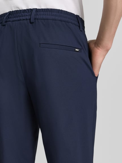 Mężczyznamodel nosi Slim Fit Anzughose mit Tunnelzug Modell 'GENIUS' od BOSS, granatowy, jednolity, elastan, krój slim fit, detal tylny, zbliżenie tylnej części.