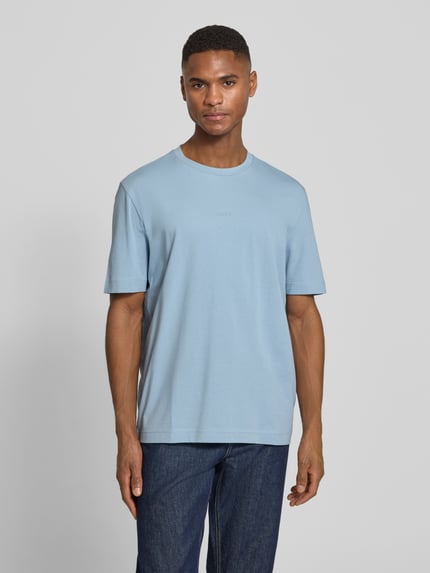 Männermodel trägt Regular Fit T-Shirt aus Baumwoll-Mix Modell 'TCHUP' von BOSS Orange, unifarben, Rundhals, Feinripp, Ganzkörperansicht von vorne.