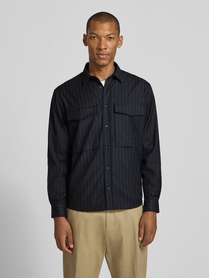 Męski model nosi Regular Fit Overshirt mit Pattentaschen od Antony Morato, Mieszanka materiałów z dodatkiem wiskozy, krój regular fit, kołnierzyk typu kent, listwa guzikowa, kieszenie z patką, zaokrąglony dół, sportowe mankiety, długość tyłu w rozmiarze 46: 75 cm, widok całej sylwetki z przodu