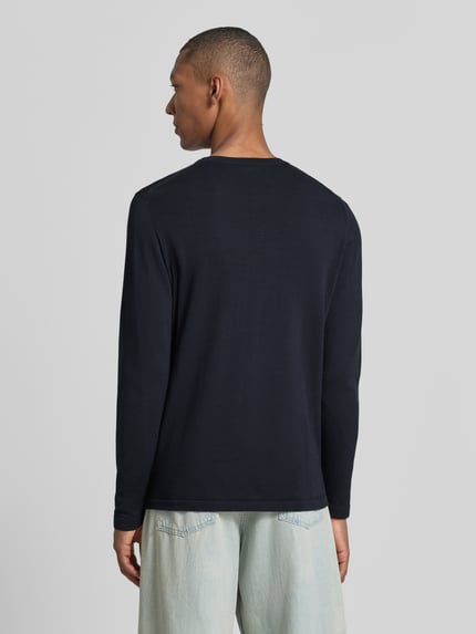 Männermodel trägt Slim Fit Langarmshirt reine Baumwolle von DRYKORN in zwart met ribboordjes, Ronde hals, Ganzkörperansicht Rückansicht, Ruglengte maat M 70 cm, Mouwlengte maat M 70 cm.